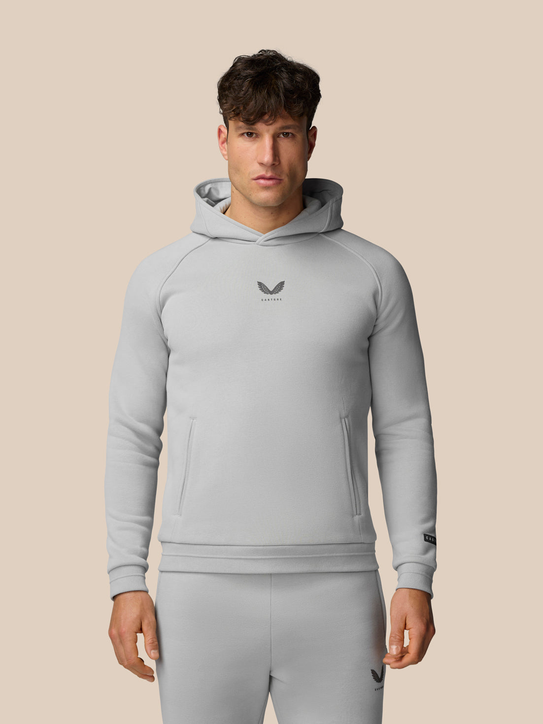 Male model in light grey Adapt Fleece Hoodie with hood and front pockets