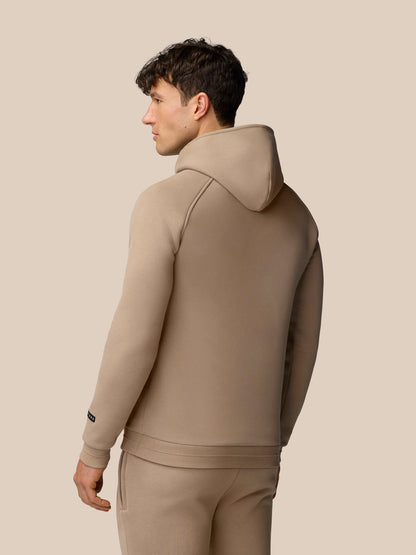 Back view of a male model wearing clay Adapt Fleece Hoodie showing the hood and clean seam lines.