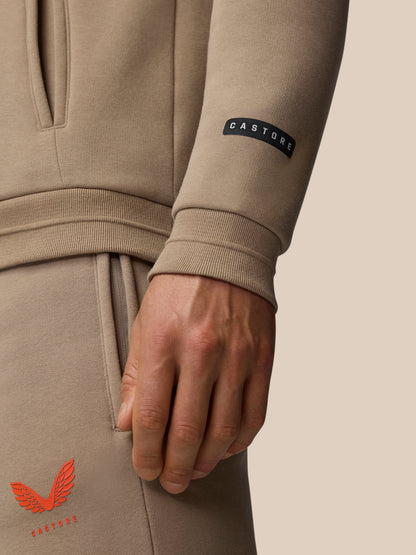 Close up of beige Adapt Fleece Hoodie sleeve with black Castore branding tag and cuff detail.