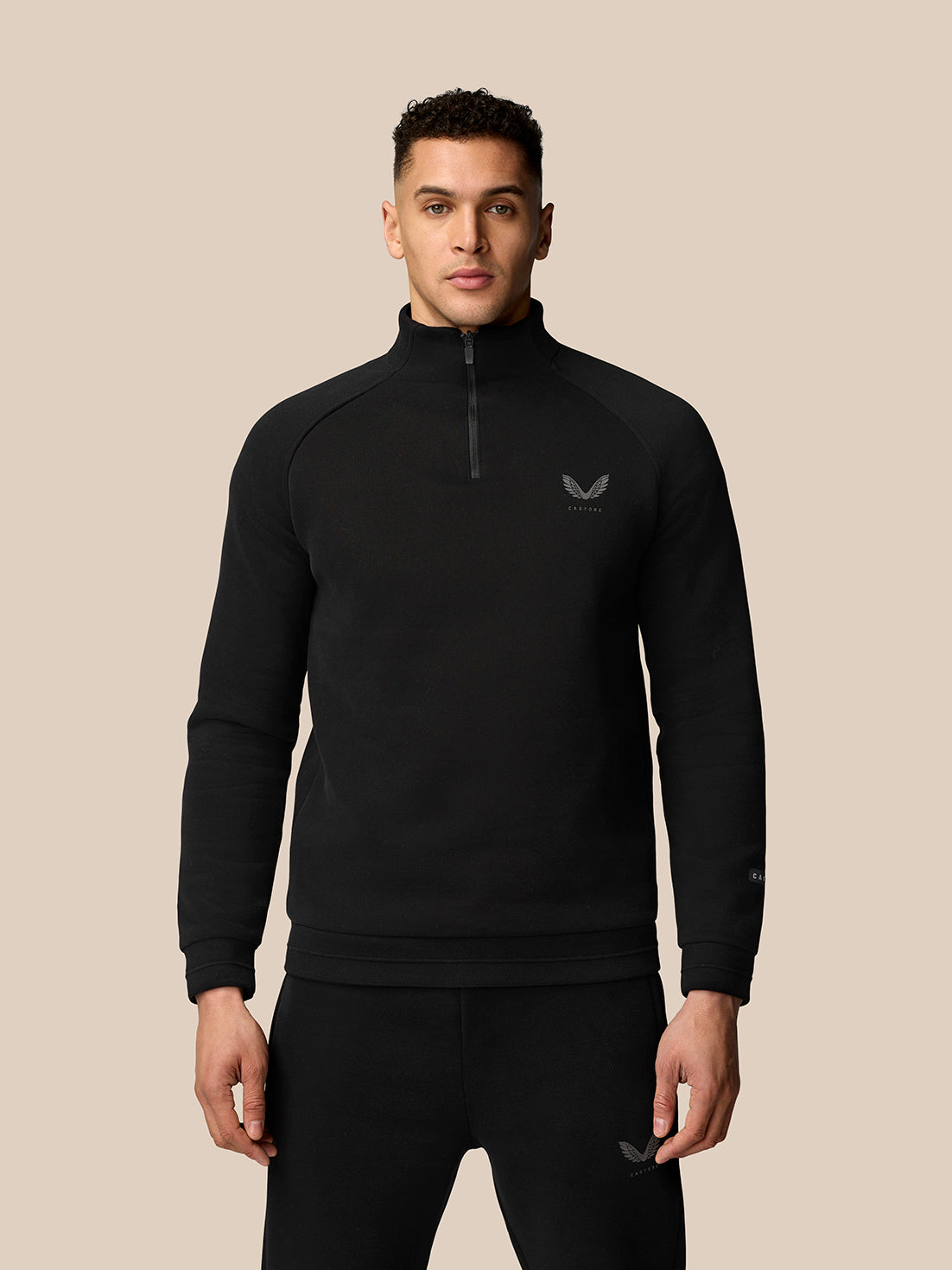 Male model wearing black Adapt Fleece Quarter Zip with zip front and subtle logo on the chest.