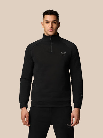 Male model wearing black Adapt Fleece Quarter Zip with zip front and subtle logo on the chest.