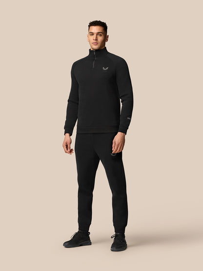 Model in black Adapt Fleece Quarter Zip with matching joggers, both featuring subtle logos for a coordinated look.