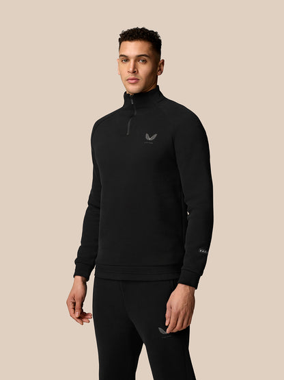 Male model wearing black Adapt Fleece Quarter Zip with high collar and subtle logo on chest.