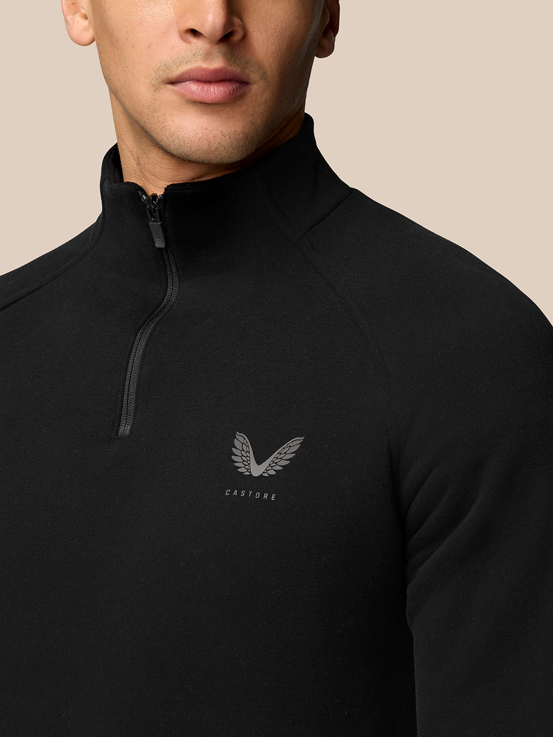 Close up of black Adapt Fleece Quarter Zip highlighting the half zip and small logo on the chest.