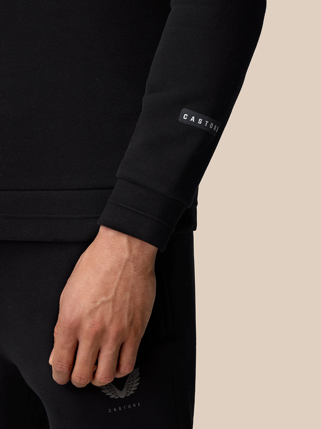 Close up of a black fleece sleeve with a CASTORE label and the winged CASTORE chest logo visible.
