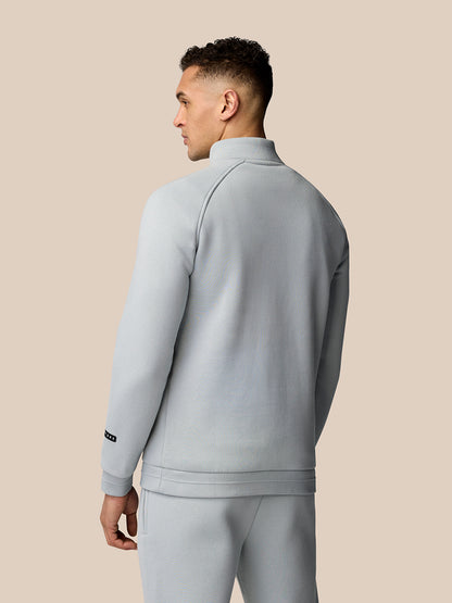 Back view of light grey Adapt Fleece Quarter Zip showing seam lines and sleeve logo patch