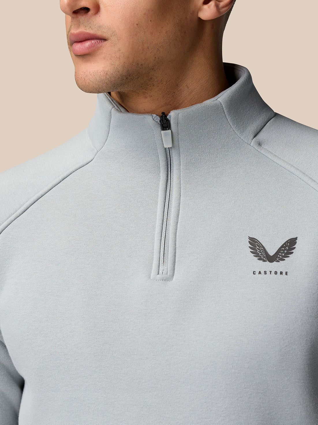 Close-up of the zip placket on light grey Adapt Fleece Quarter Zip with Castore logo visible on the chest