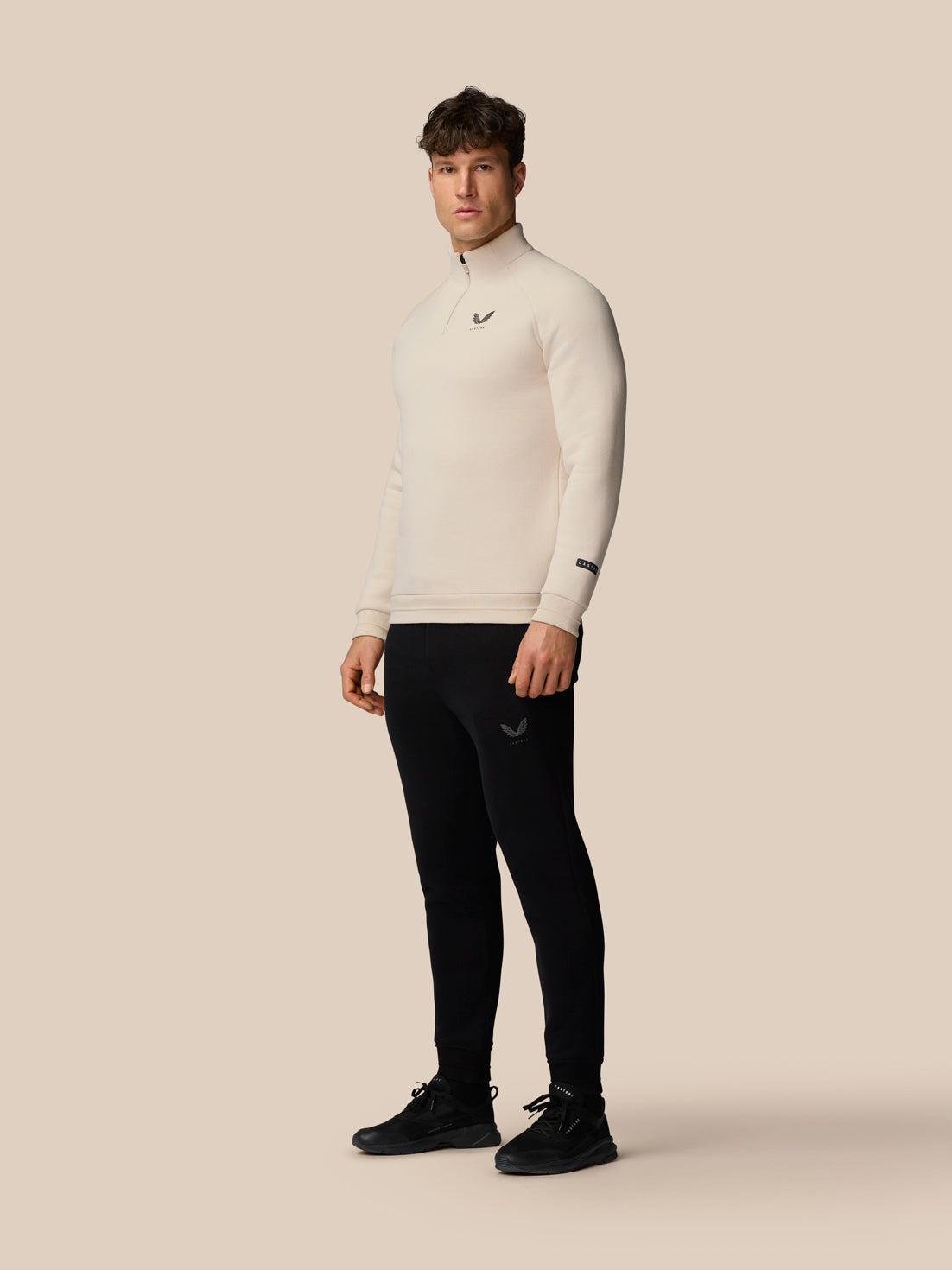 Full body shot of male model in Adapt Fleece Quarter Zip Stone with zip neck and matching outfit