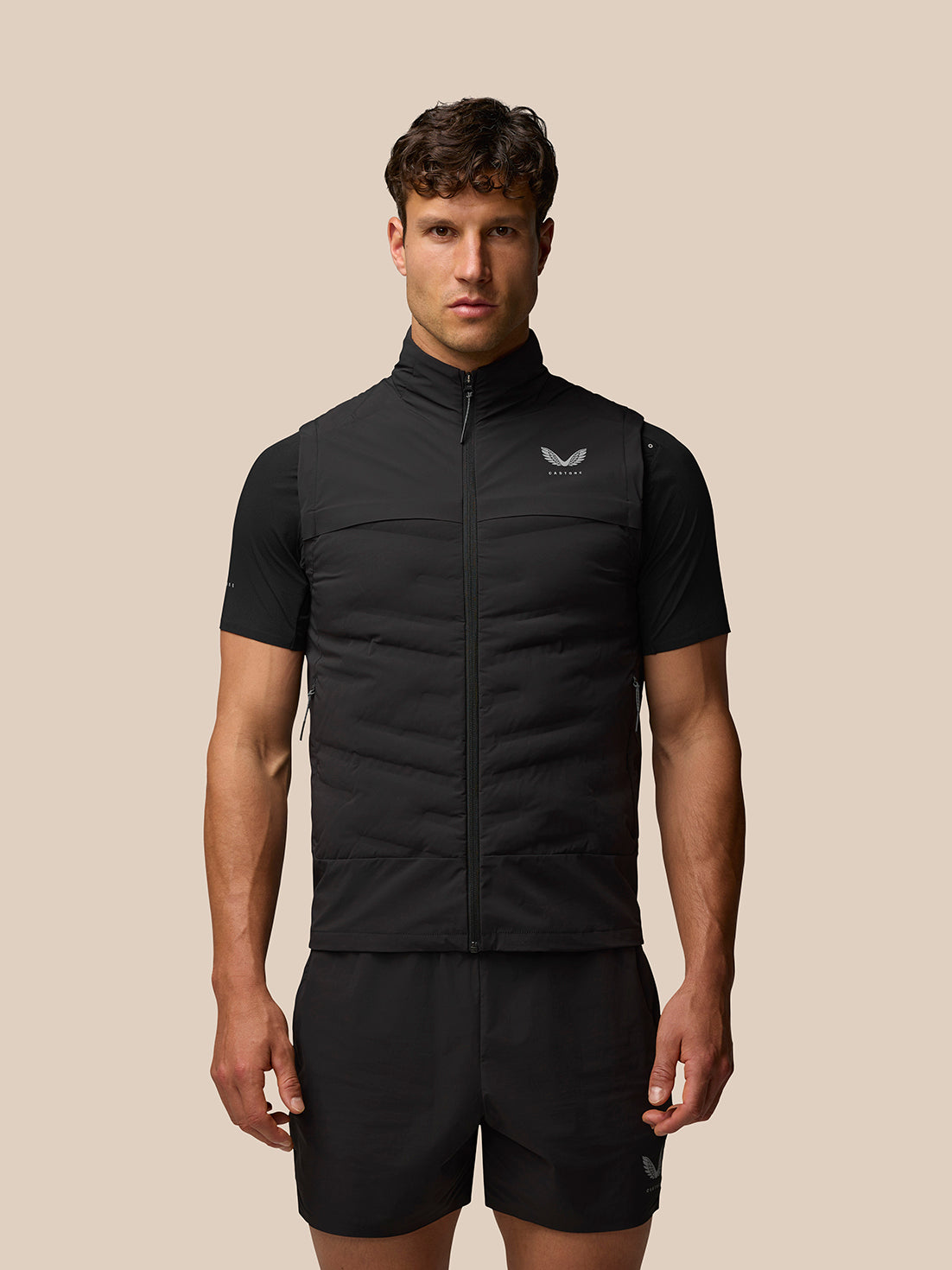 Male model wearing front view of black Zone Training Gilet with padded sleeveless shell and Castore logo on chest