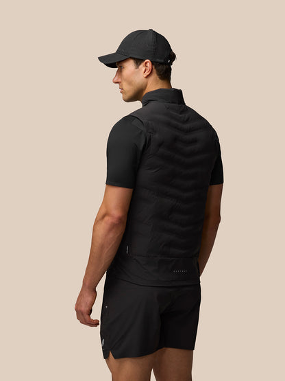 Model from behind wearing black Zone Training Gilet with padded sleeveless silhouette and reflective branding on the lower back