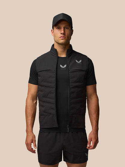 Male model wearing black Zone Training Gilet over a black top with cap and shorts.