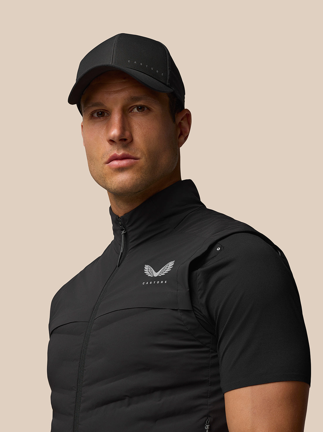 Male model in black Zone Training Gilet shown from the front with zipped closure and Castore logo on the chest