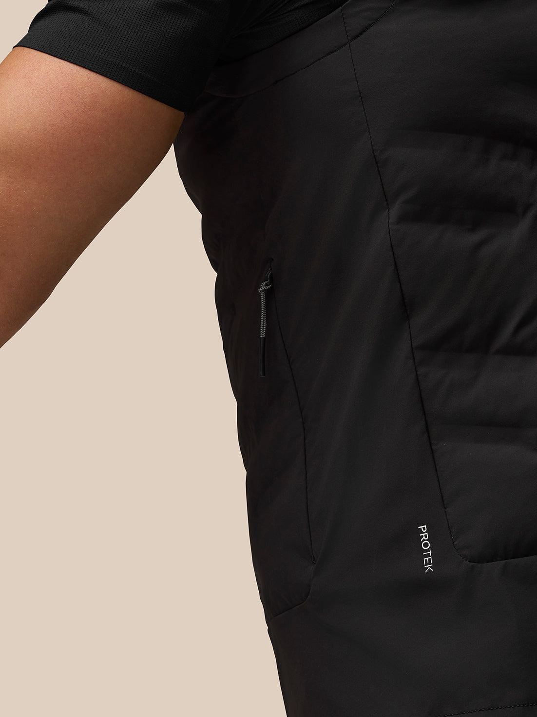 Close-up of black Zone Training Gilet showing side zip pocket and ProTek branding along the seam