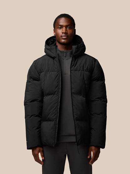 Male model wearing a black hooded puffer jacket with front zip and ProTek branding on the sleeve.