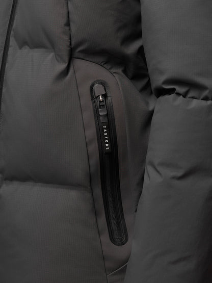 Close-up of a charcoal jacket pocket with vertical zip and Castore branding on the zipper pull.