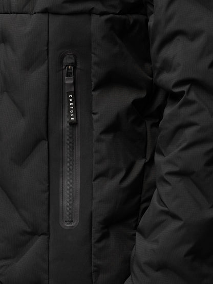 Close-up of a vertical zip pocket on a black padded jacket with Castore branding on the zipper pull
