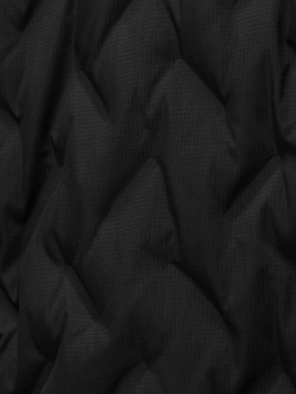Close-up of black textured jacket fabric with a subtle grid pattern and folds.