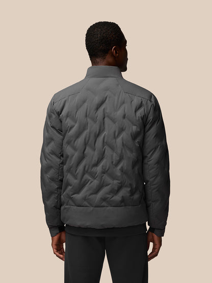 Back view of charcoal padded jacket on a model, displaying a quilted chevron pattern and high collar.