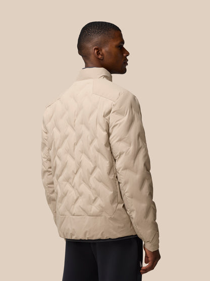Back view of a man wearing a mushroom colored padded jacket with a quilted pattern and high collar.