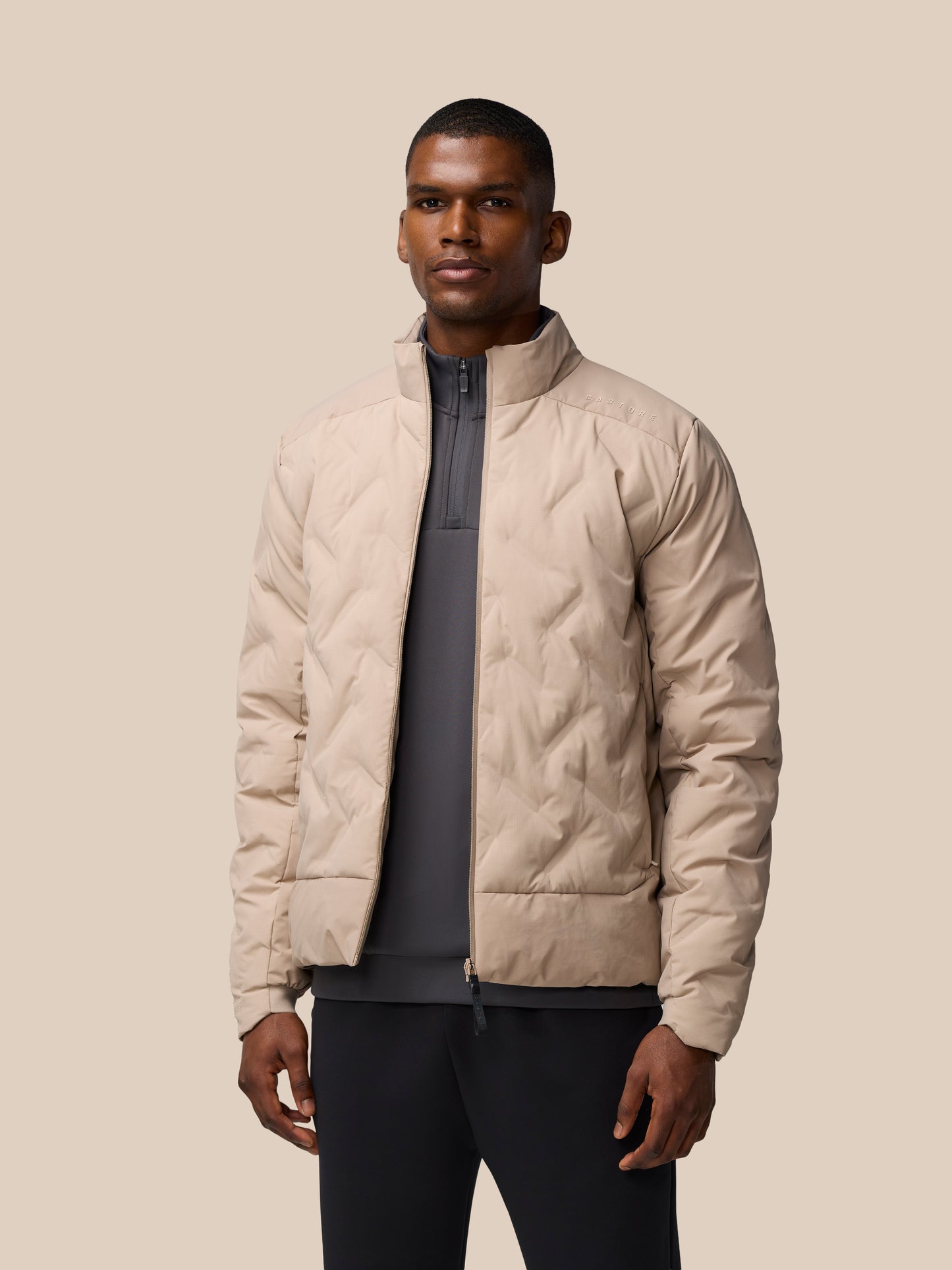 Male model in mushroom padded jacket with zip front and quilted panels