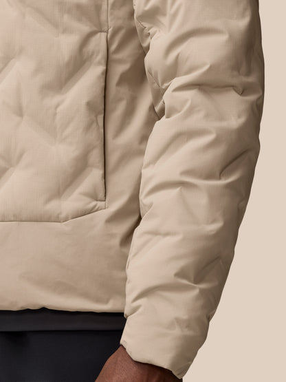 Close up of mushroom colored padded jacket fabric with quilted panels and seam details