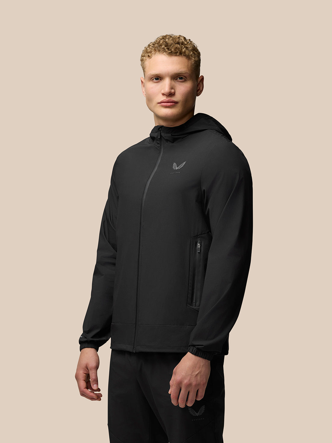 Front view of man in black Flex Lifestyle Jacket with three piece hood full front zip and zip pockets left chest silicon branding