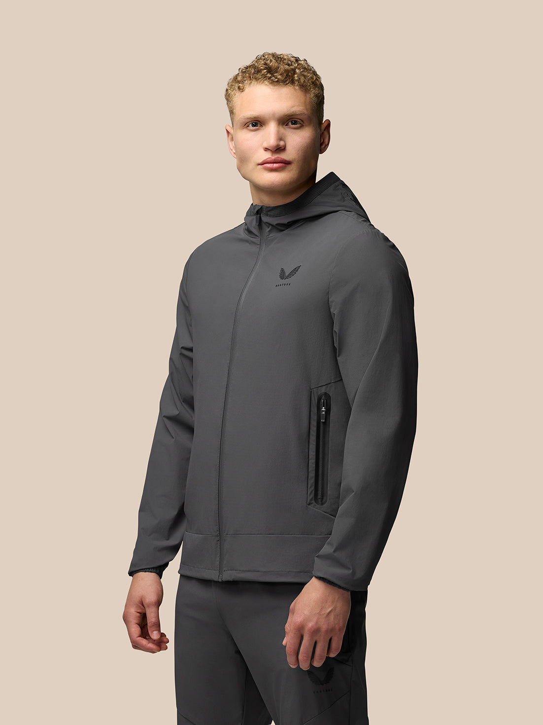 Male model wearing gunmetal Flex Classic Lifestyle Jacket with hood and zip pockets