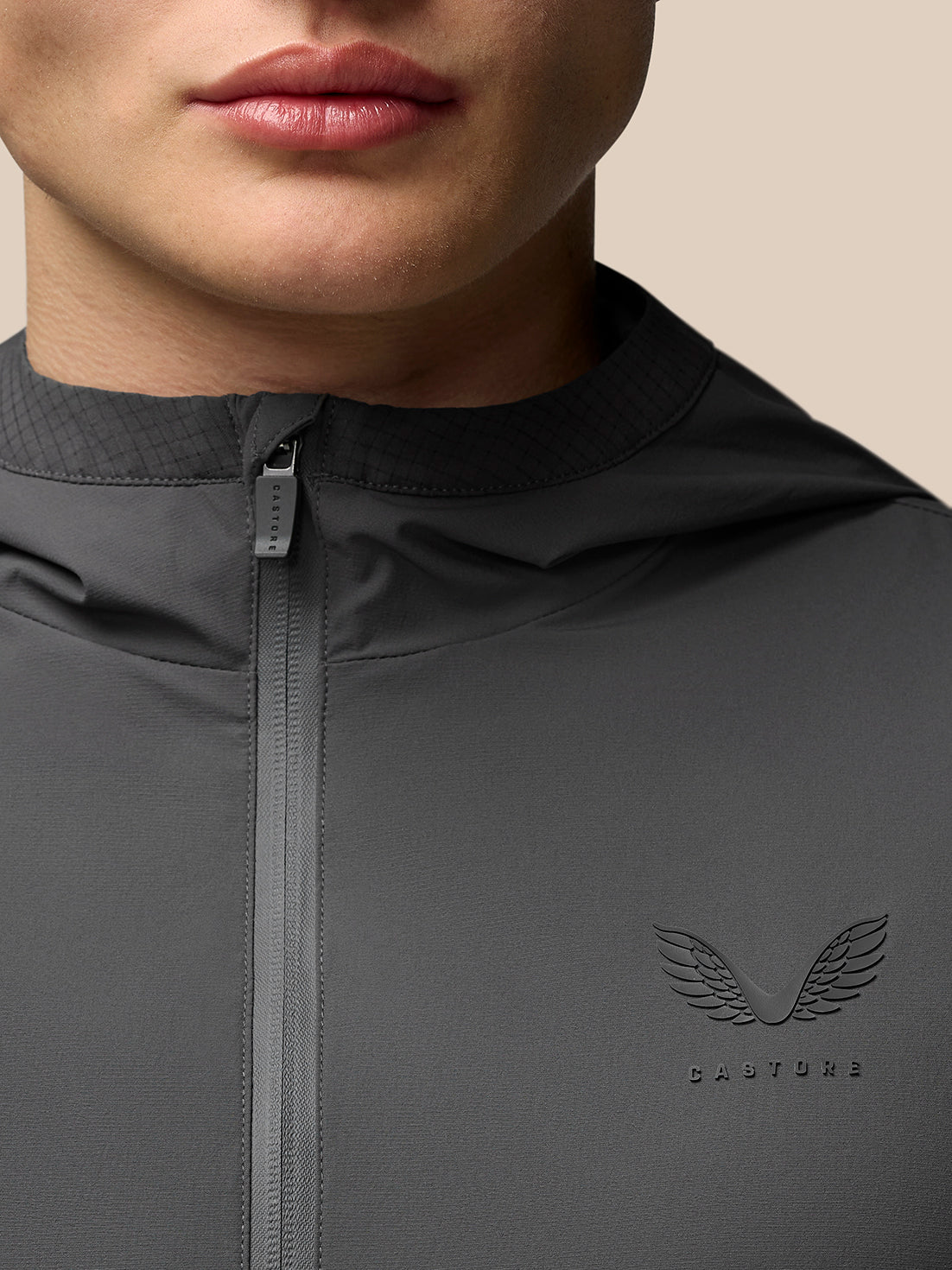 Close up of gunmetal Flex Classic Lifestyle Jacket showing front zipper and textured collar with a winged Castore logo on the chest.