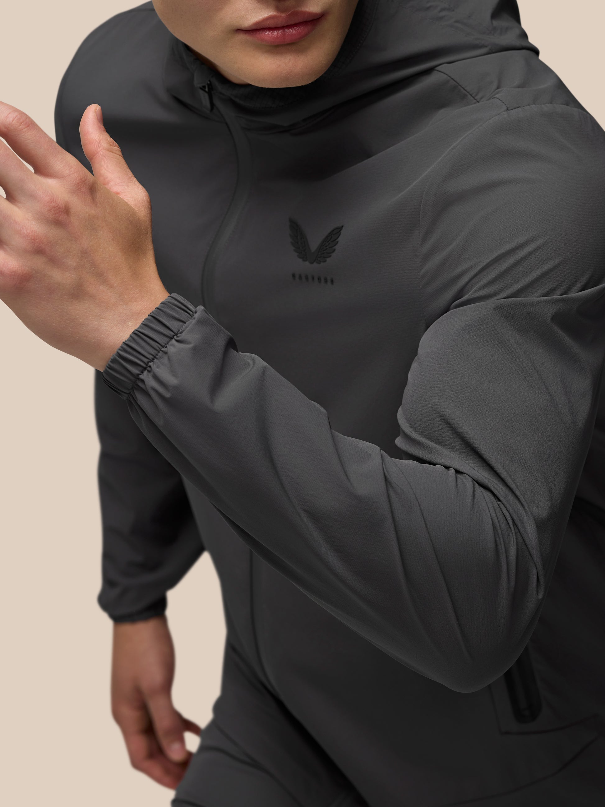 Close-up of a gunmetal Flex Classic Lifestyle Jacket with hood, front zipper, chest logo, and elastic cuffs.