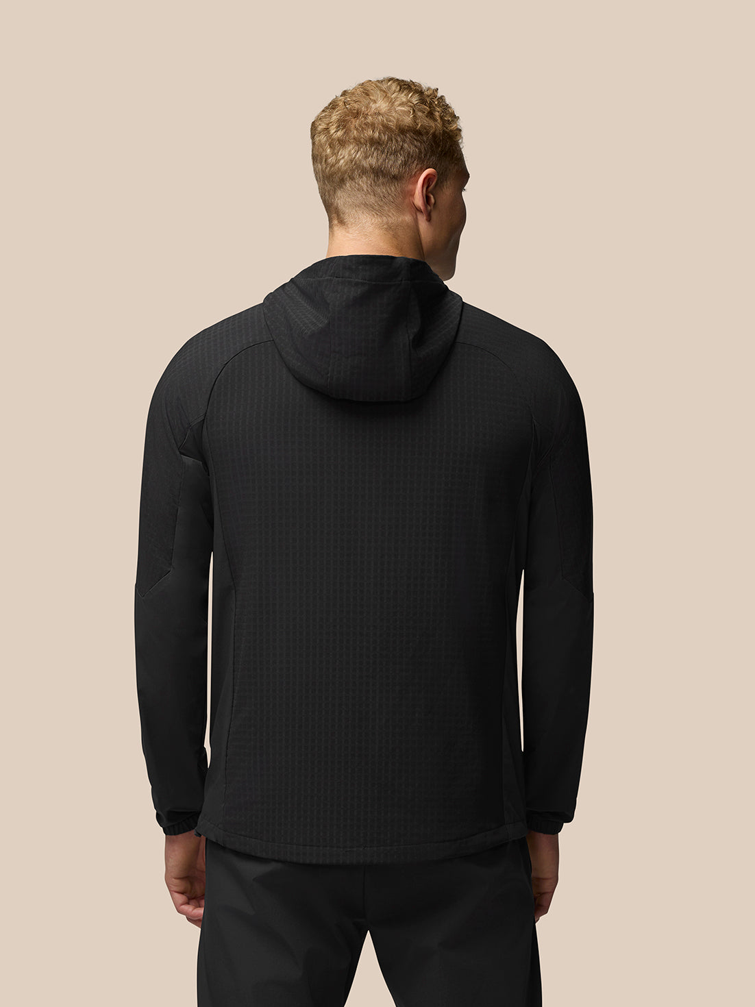 Back view of black Flex Winterised Jacket with hood and subtle textured fabric, showing a straight hem and elastic cuffs.