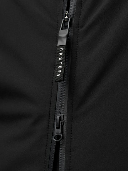 Close-up of a black jacket zipper with a Castore branded pull on smooth black fabric.