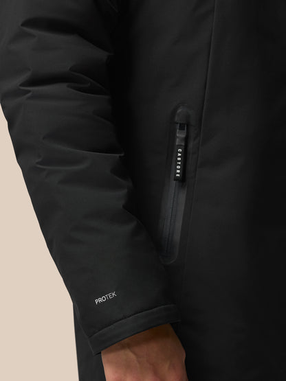 Close-up of black Longline Wadded Jacket focusing on front zipper with Castore pull and ProTek branding on the cuff.