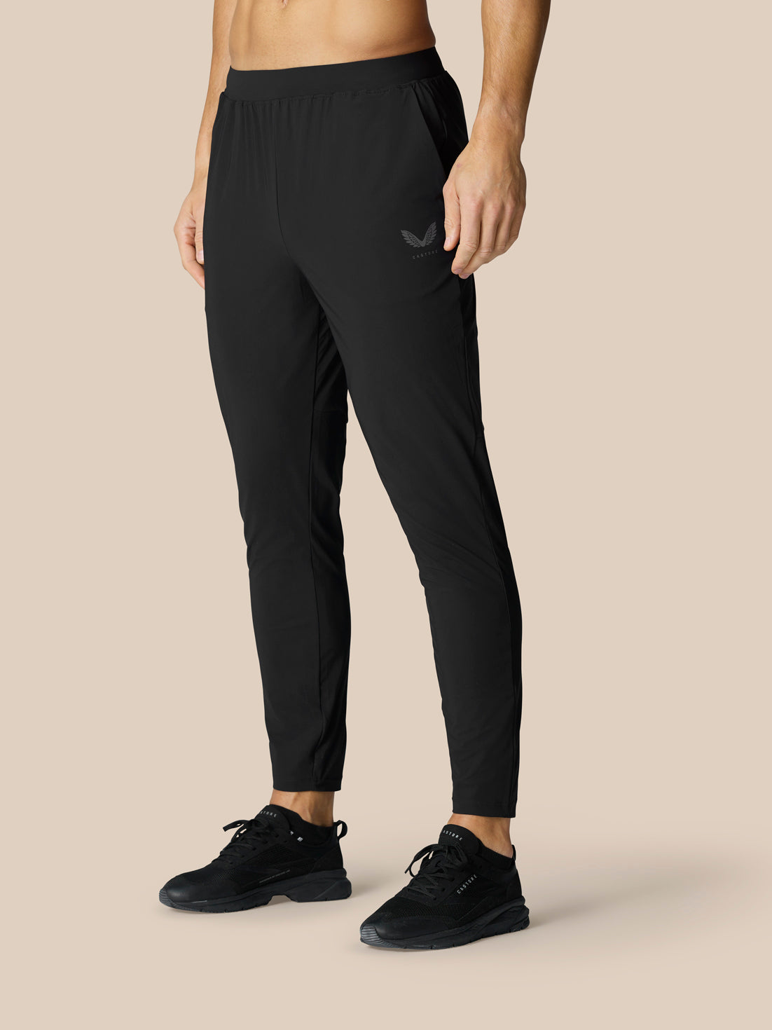 Back view of a model wearing black Adapt Tech Training Trousers with an elastic waistband
