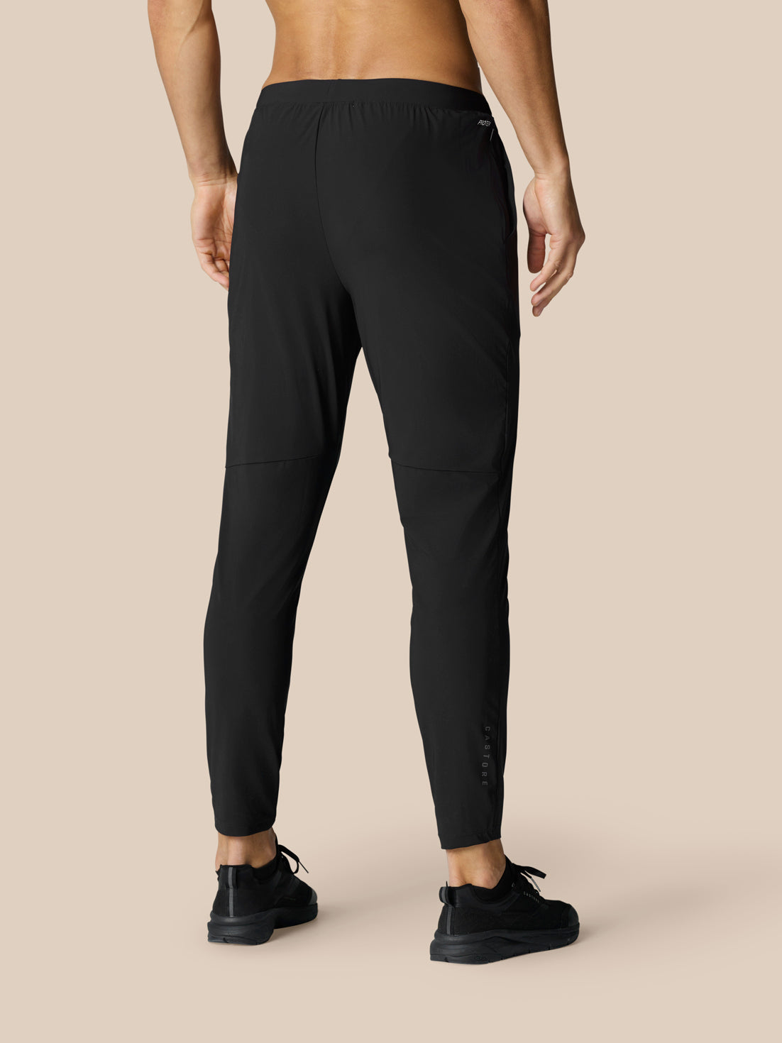 Back view of black Adapt Tech Training Trousers on a model showing tapered legs and cuffs