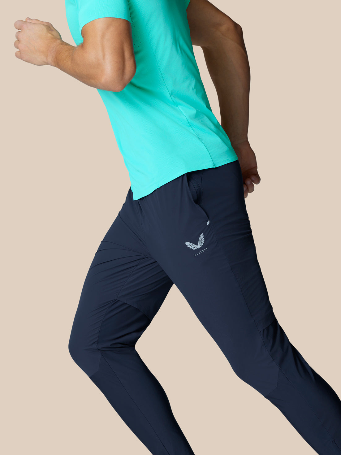 Side view of Zone Training Trousers Midnight Navy on a runner with thigh logo and breathable paneling