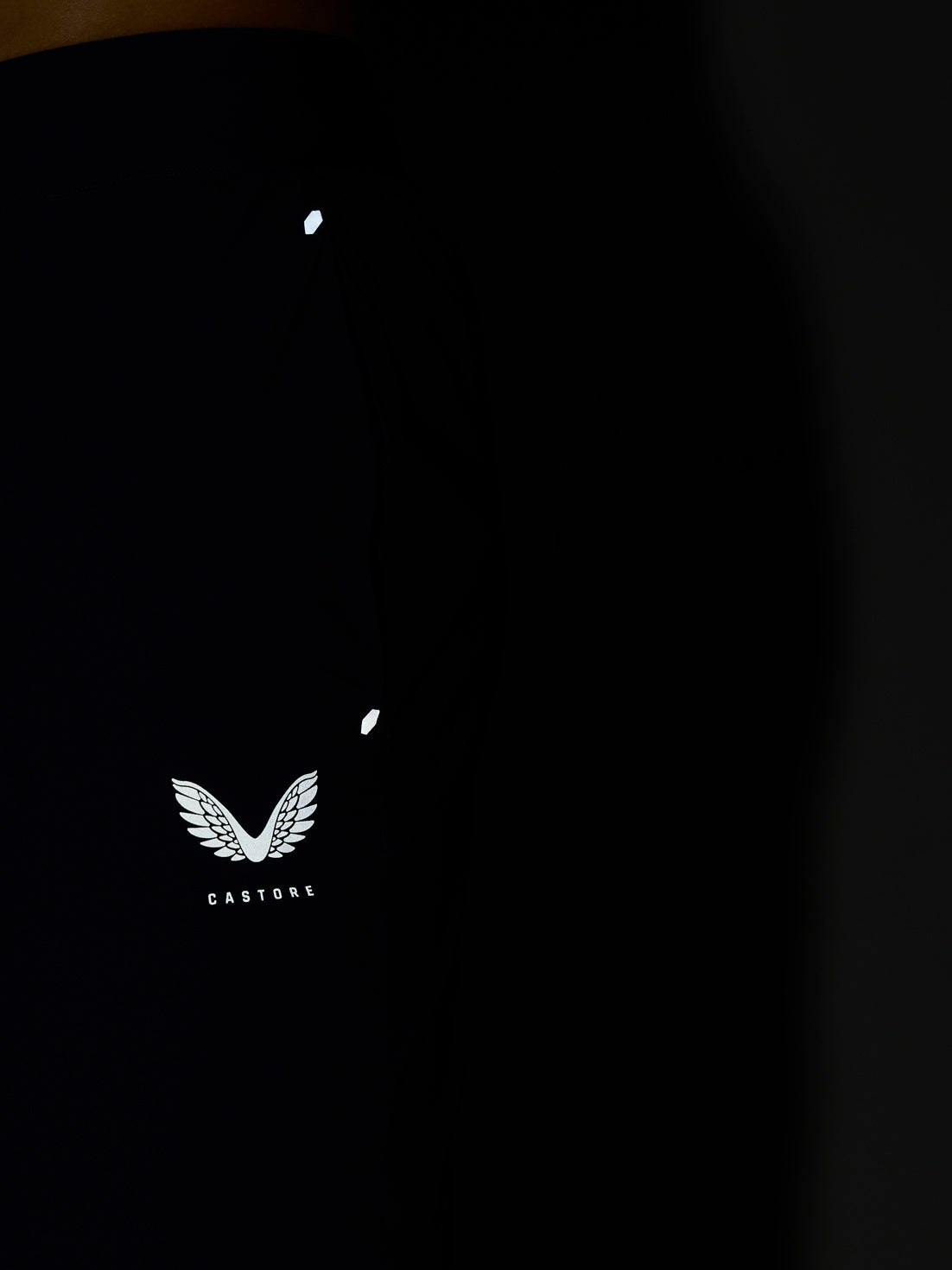Close-up of white Castore wing logo on black athletic top