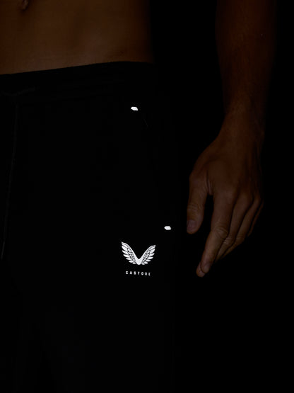 Close up of the waist area of Travel Lifestyle Joggers in black showing elastic waistband and Castore logo on leg