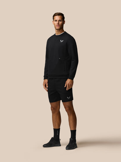 Model wearing black Travel Lifestyle Shorts with concealed zip pockets and Castore logo on leg