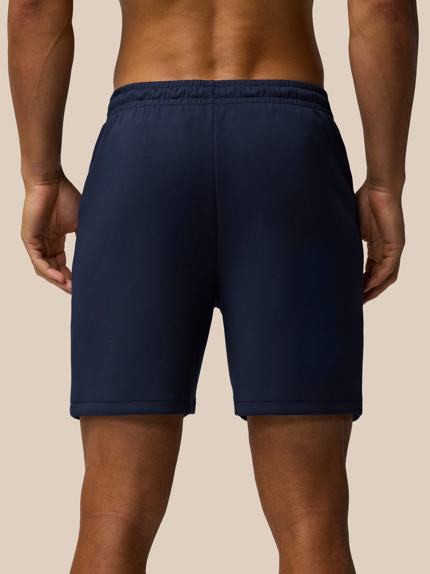 Back view of navy Travel Lifestyle Shorts showing the elastic waist and clean seams with Castore logo at the hem