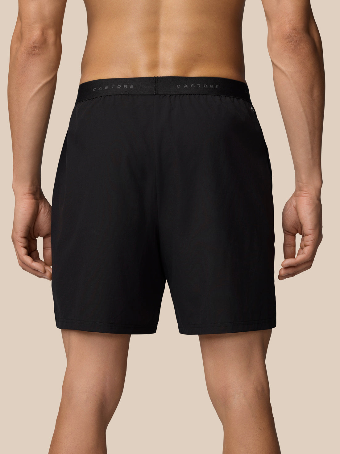 Back view of black Adapt Training Shorts showing elastic waistband with Castore branding across the band