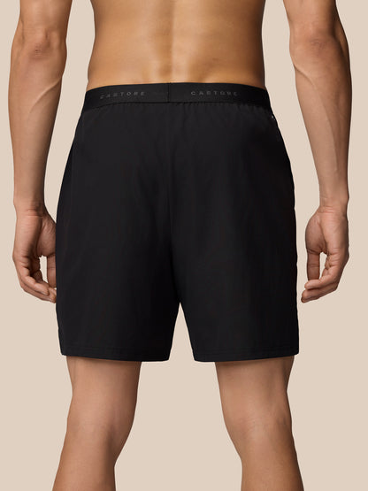 Back view of black Adapt Training Shorts showing elastic waistband with Castore branding across the band