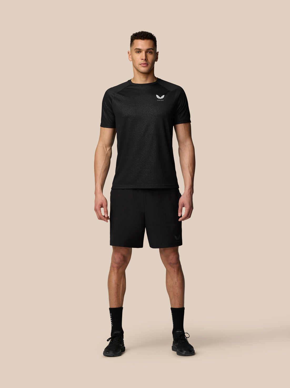 Male model wearing black Adapt Training Shorts with side pockets and internal drawcords
