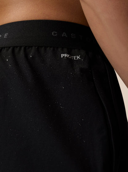 Close-up of black Adapt Training Shorts waistband with PROTEK label and Castore branding.