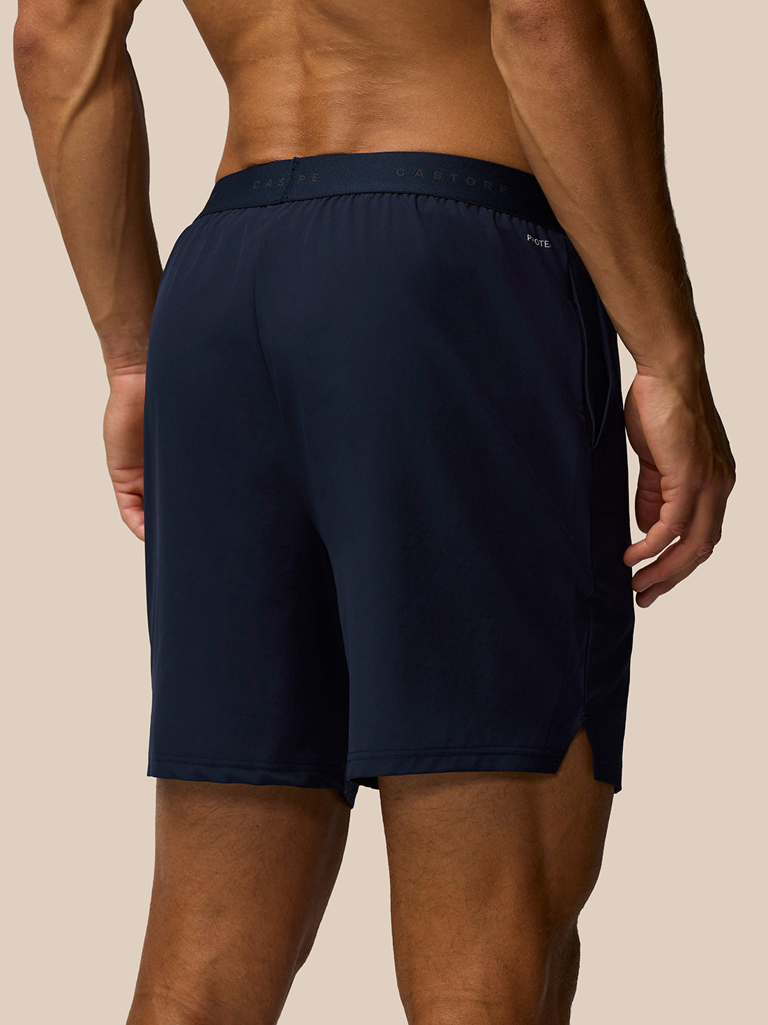 Back view of midnight navy Adapt Training Shorts on a model, displaying the branded waistband and relaxed fit.