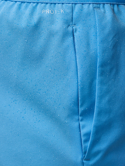 Blue waistband close up on Adapt Shorts showing ProTek branding and moisture droplets.