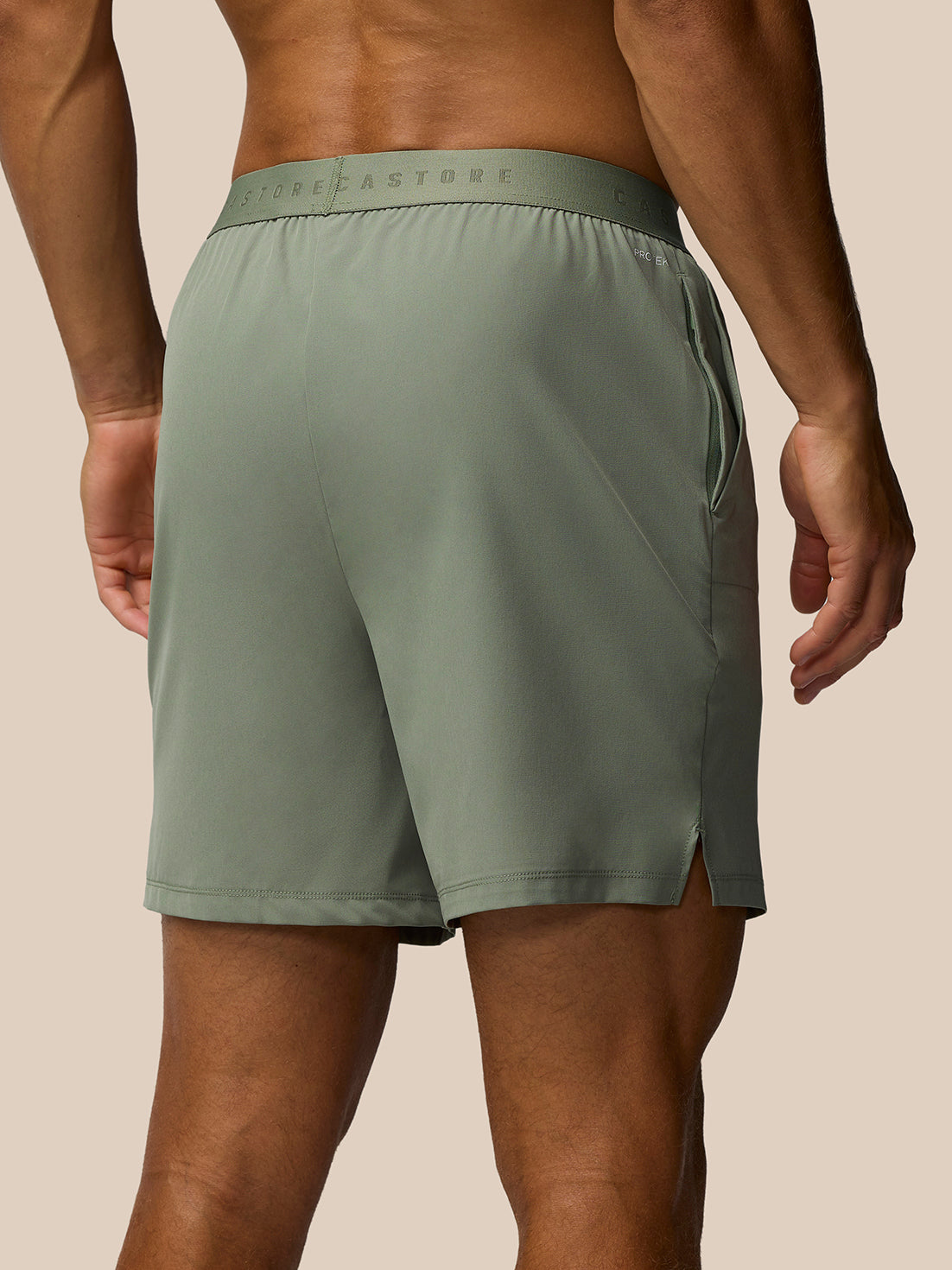 Back view of Adapt training shorts in Thyme Mint showing branded waistband and zip pocket at the right hip.