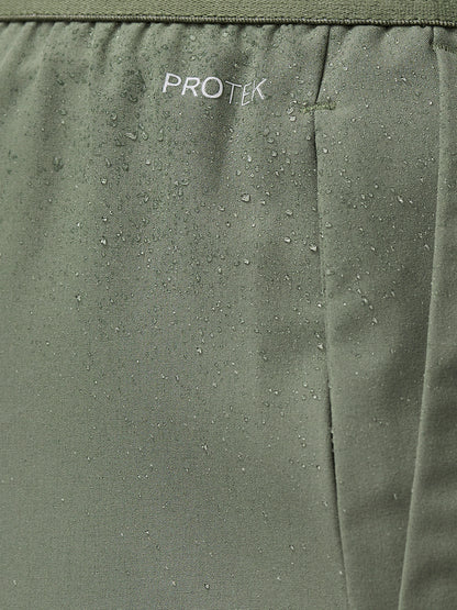 Close up of thyme mint Adapt Training Shorts fabric with water droplets and ProTek branding.