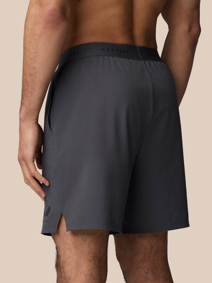 Back view of dark gunmetal Adapt Training Shorts with Castore waistband branding and a side pocket.
