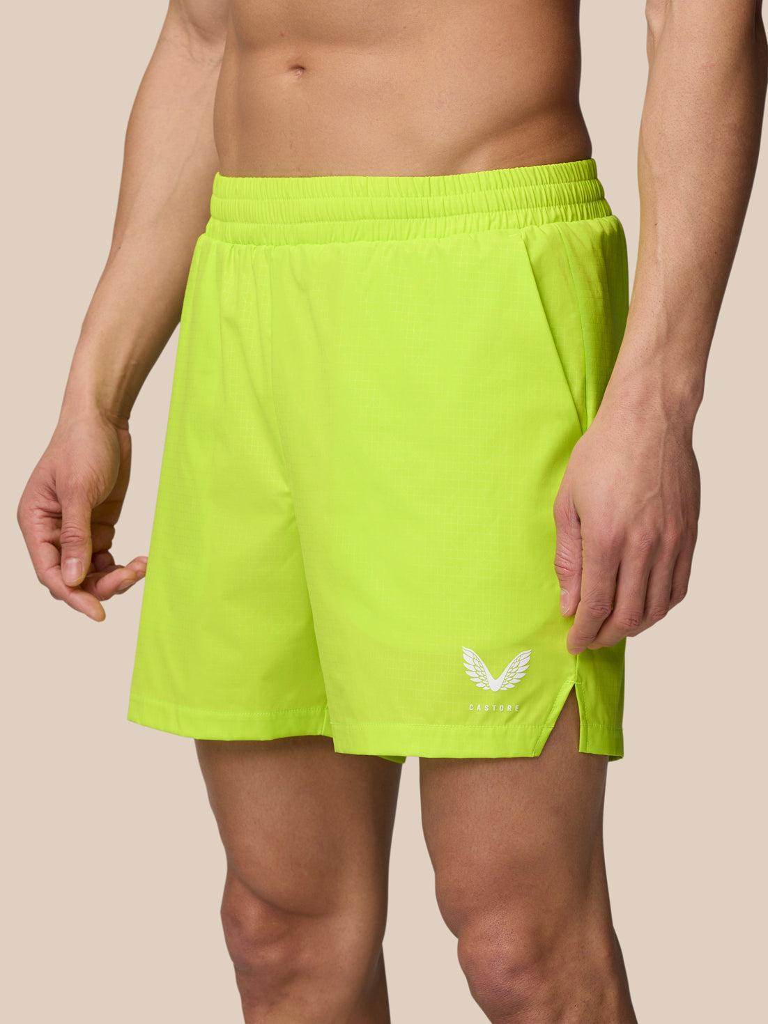 Neon lime Adapt Swim Shorts on a model with a white logo near the leg hem