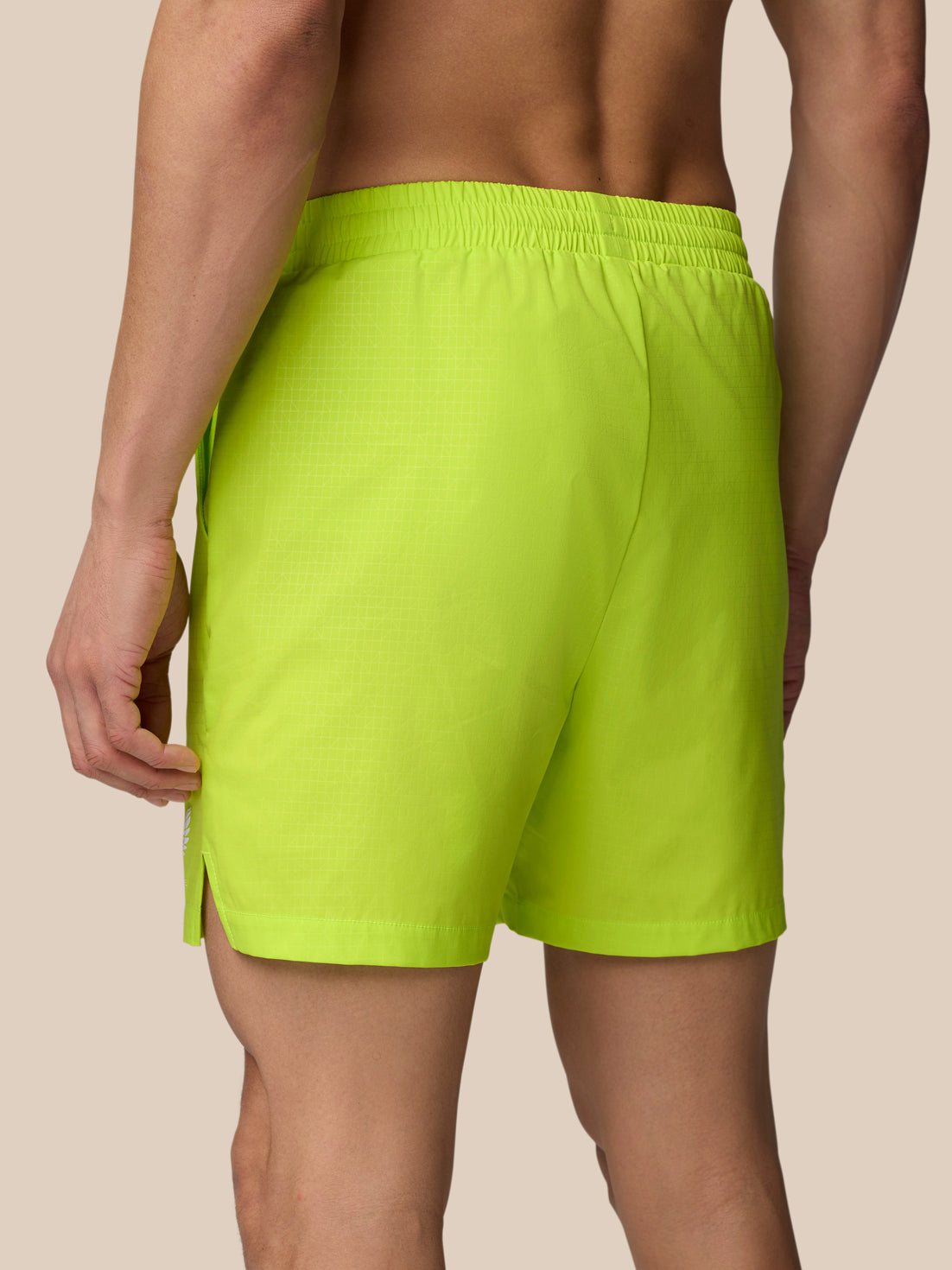 Back view of acid lime Adapt Swim Shorts with elastic waistband and a side zip pocket